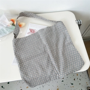 Detail of canvas tote bag featuring geometric honeycomb pattern and wide shoulder strap