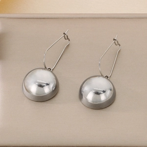 Detail view of silver hollow hemisphere earrings with polished stainless steel finish