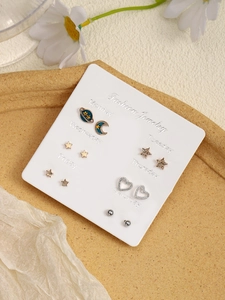 Detailed set of fashion earrings featuring planet, moon, and heart designs on card