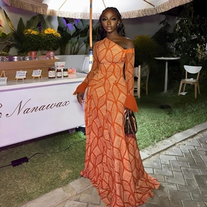 Detail of orange one-shoulder maxi dress with white wavy geometric patterns and long sleeve