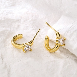 Minimalist 18K gold plated copper earrings with zircon stones on white stone surface