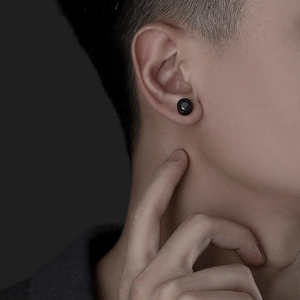 Close-up of men's black titanium steel stud earring with inset cubic zirconia on ear