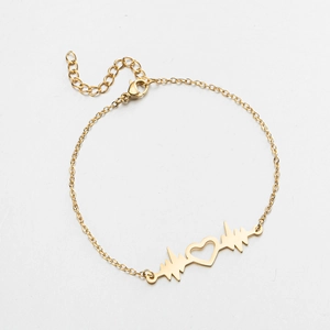Détail du pendentif cœur doré et ligne de battement de cœur sur bracelet acier inoxydable