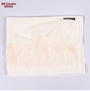 Detail of milky white cashmere scarf showing the soft texture and fringed edges