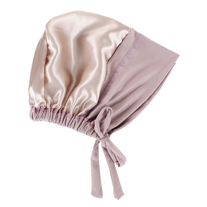 Detailed close-up of champagne satin bonnet with lilac elastic band and long tie straps