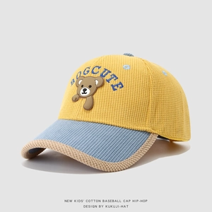 Detail of a yellow and blue corduroy kids baseball cap with a cute bear patch