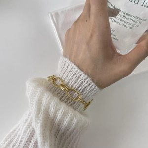 Close-up of a chunky 925 sterling silver chain bracelet with a stylish gold toggle clasp