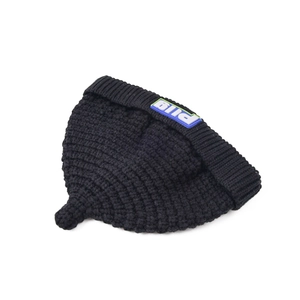 Detail of black knitted baby beanie with colorful rubber logo and pointy top design