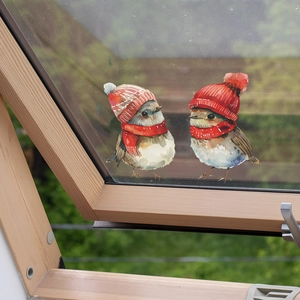 Winter bird window clings featuring watercolor birds with red hats and scarves on glass