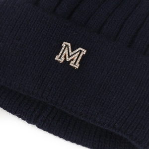 Détail du bonnet en maille bleu marine avec lettre M dorée et cristaux brillants