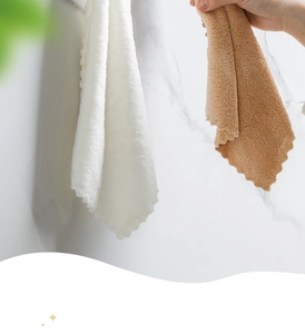 Close-up of white and camel coral fleece towels with elegant wavy edges on marble