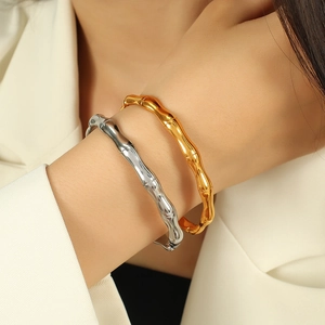 Polished bamboo joint bangle in gold and silver finish worn on wrist for minimalist style