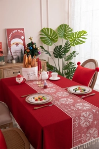 Macro shot of red Christmas tablecloth with white snowflakes, bows and decorative tassels