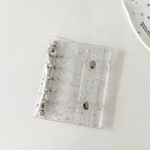 Detail of transparent PVC binder cover with silver star patterns and 6-hole metal ring