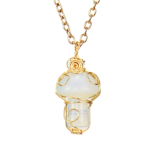 Detail of handmade wire-wrapped opal mushroom pendant on a gold link chain necklace