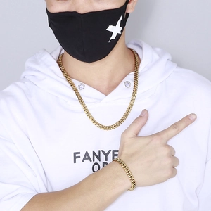 Close-up of a gold-plated Cuban link chain necklace and bracelet set on a male model