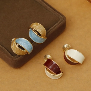 Close-up of pearl enamel clip-on earrings in assorted vintage colors on a jewelry box