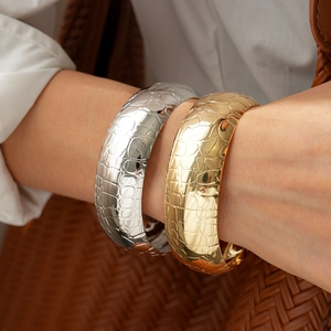 Fashionable gold and silver wide cuffs with crocodile texture pattern for a luxury look