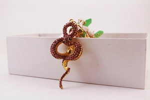 Close-up of golden snake keychain with red crystal pavé and black rhinestone eyes