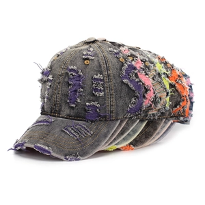Detail of distressed denim baseball caps showing colorful ripped holes and textures