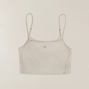 Detail of beige cropped sports vest featuring soft brushed fabric and a center cross logo