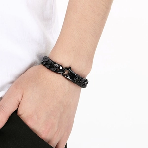 Détail du bracelet gourmette en acier noir avec gravures de motifs de flammes complexes