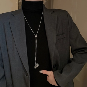 Detailed view of silver long tassel sweater necklace with hollow spherical pendants on a model