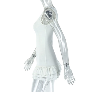 Side view of sleeveless white mini dress with layered ruffle hem on mannequin