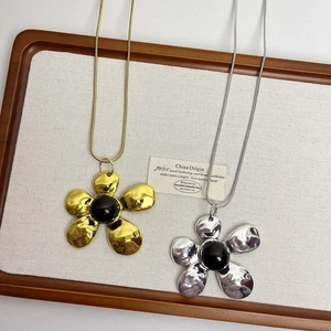 Vintage style long sweater necklace with large metallic flower pendant and black center