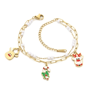 Golden stainless steel Christmas bracelet with reindeer charms and white pearls on white background