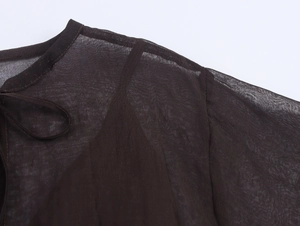 Detail of sheer dark brown chiffon fabric texture with neck tie and shoulder seam detail