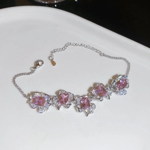 Detailed close-up of a silver-tone floral bracelet with pink zircon and lobster clasp