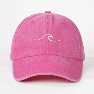 Detailed macro view of embroidered wave pattern on peach pink washed cotton baseball cap