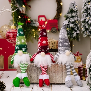 Three Christmas gnomes with knitted snowflake hats and striped legs on wooden blocks