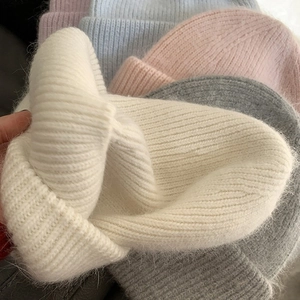 Close-up of soft rabbit fur knit beanies showing thick ribbed texture in multiple colors