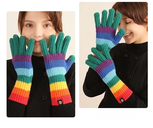 Close-up of vibrant rainbow striped knitted gloves with Nordic gradient pattern