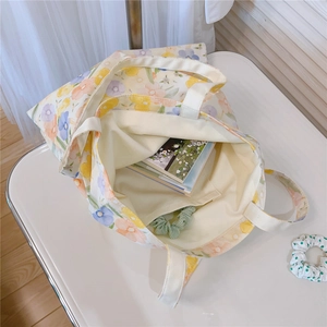 Internal detail of floral canvas tote bag featuring inner lining and small pocket