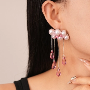Close-up of pearl cloud earrings with pink crystal tassels on model's ear