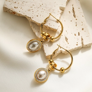 Golden geometric pearl drop earrings with zircon halo on decorative stone