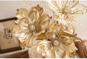 Detail of champagne gold artificial magnolia flowers with glitter and sequin accents