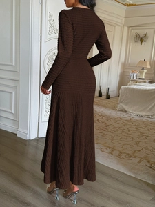 Detail of elegant brown long-sleeve textured maxi dress worn by a model in a luxury room