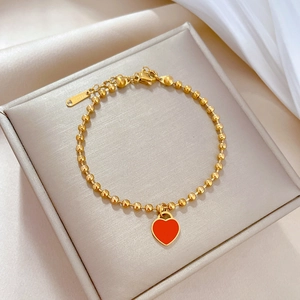 Titanium steel gold beaded bracelet featuring a red heart pendant on silk fabric