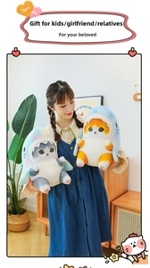 Detail of plush cat shark dolls in soft fabric being held in a cozy home setting