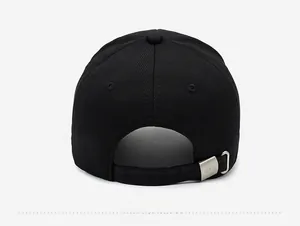 Detail of the back of a black baseball cap featuring a matte metal buckle and woven strap