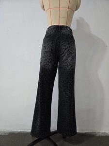 Dettaglio dei jeans a zampa a vita alta con stampa leopardata in denim grigio-nero