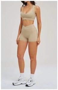 Dettaglio del set yoga kaki con reggiseno a V e pantaloncini sportivi a vita alta