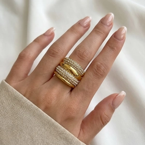 Detail of stacked gold titanium rings with multi-row pavé crystals and wide bands