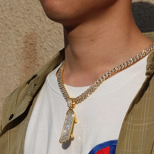 Close-up of a gold-plated Cuban chain with a crystal-encrusted scooter pendant on a model