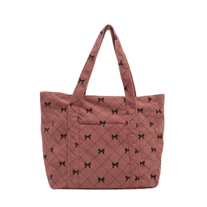 Pink corduroy tote bag with black bow patterns and external pocket for casual wear