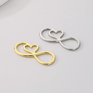 Macro detail of heart and infinity symbol jewelry connectors in gold and silver finish